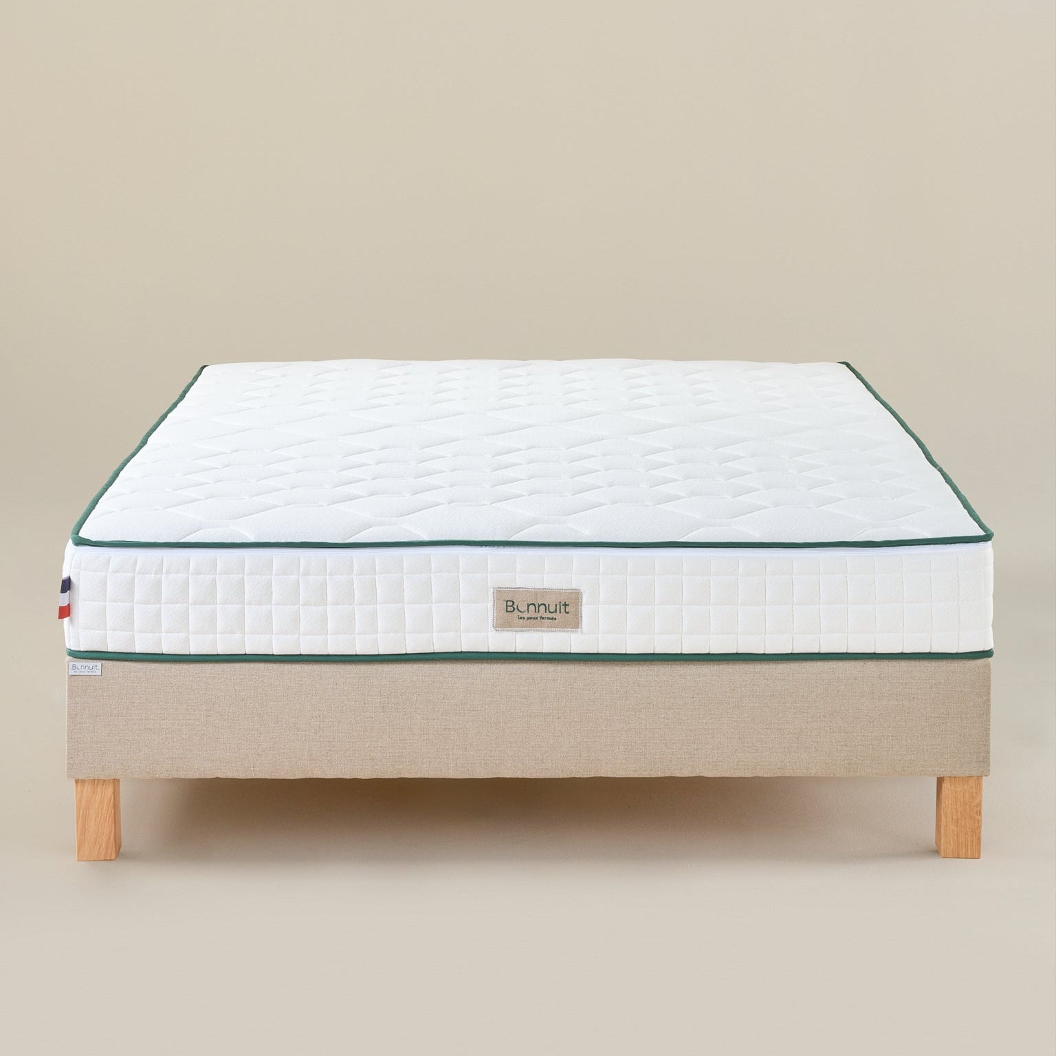 Matelas Le Naturel vu de face avec housse claire, liseré vert et logo brodé discret
