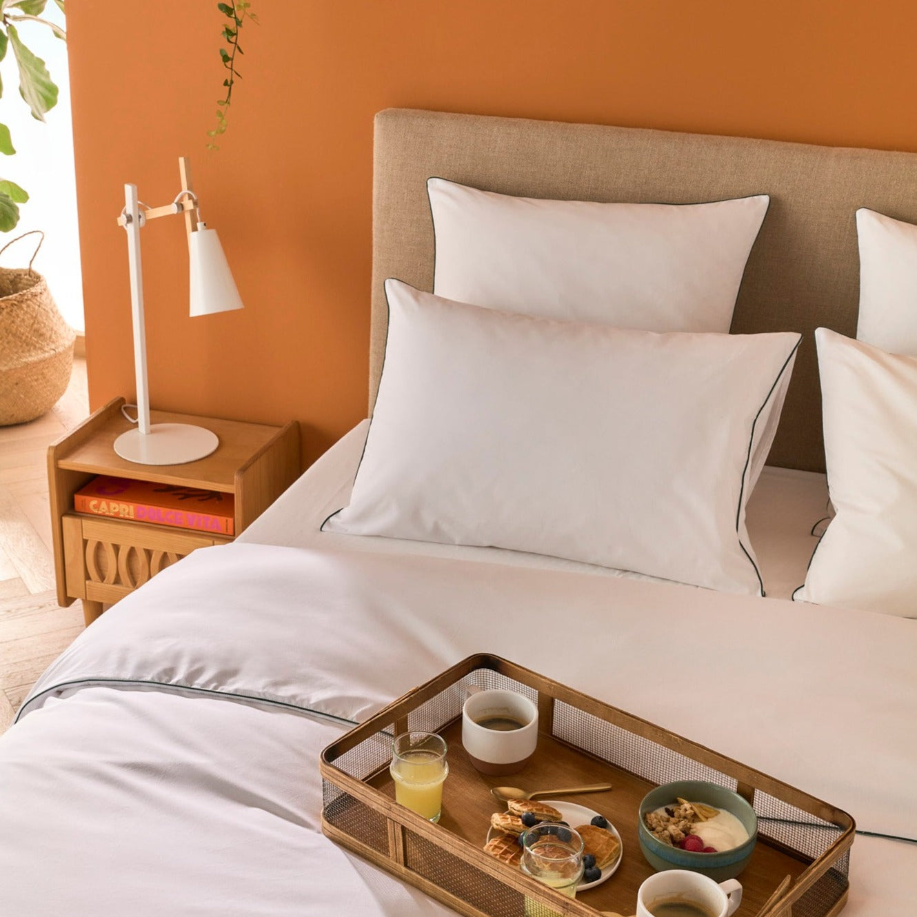 Petit déjeuner sur un lit avec parure en percale de coton blanche à liseré vert, ambiance cosy