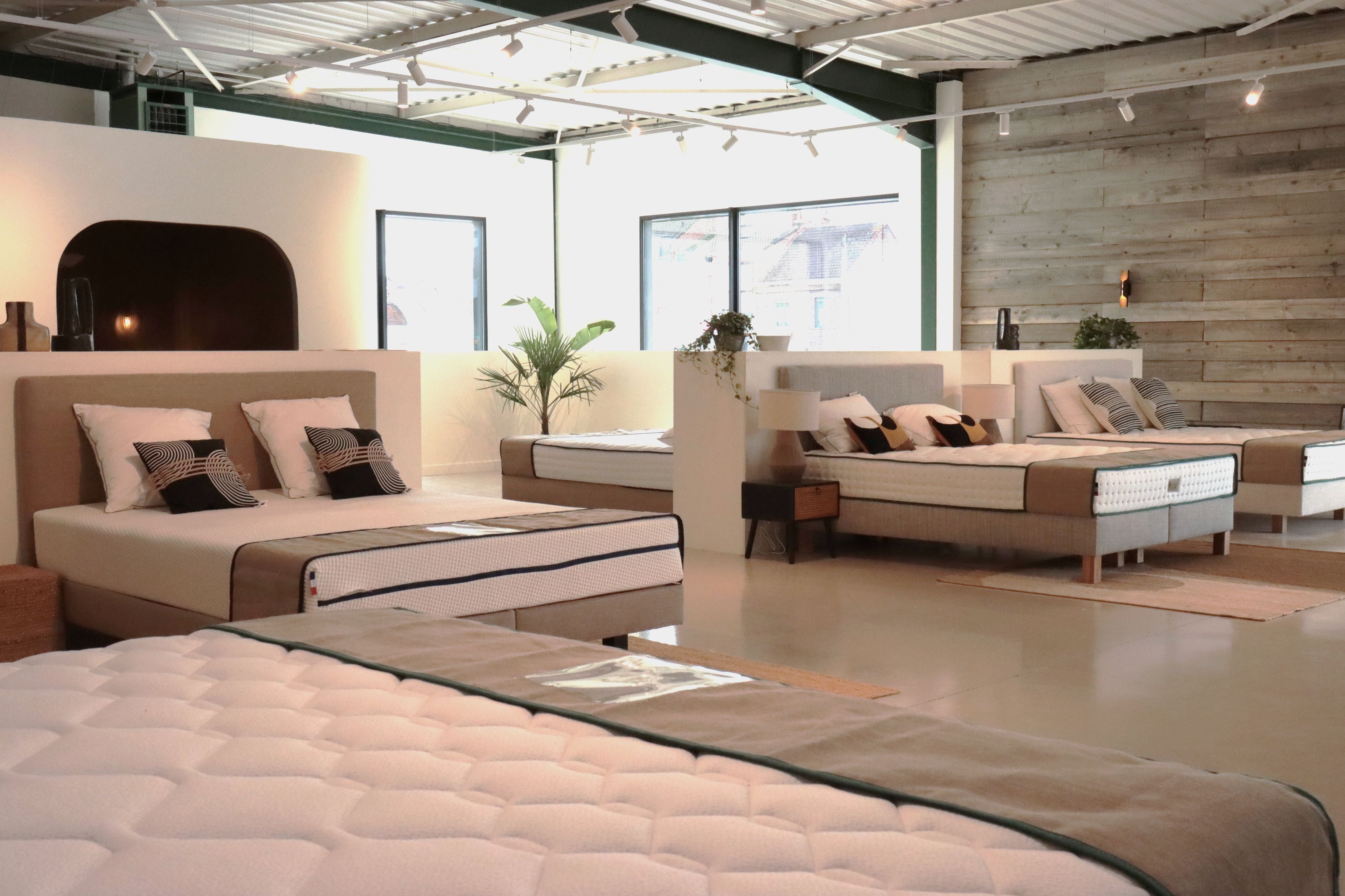 Vue du showroom Bonnuit à Bailleul avec literie exposée et décoration végétale