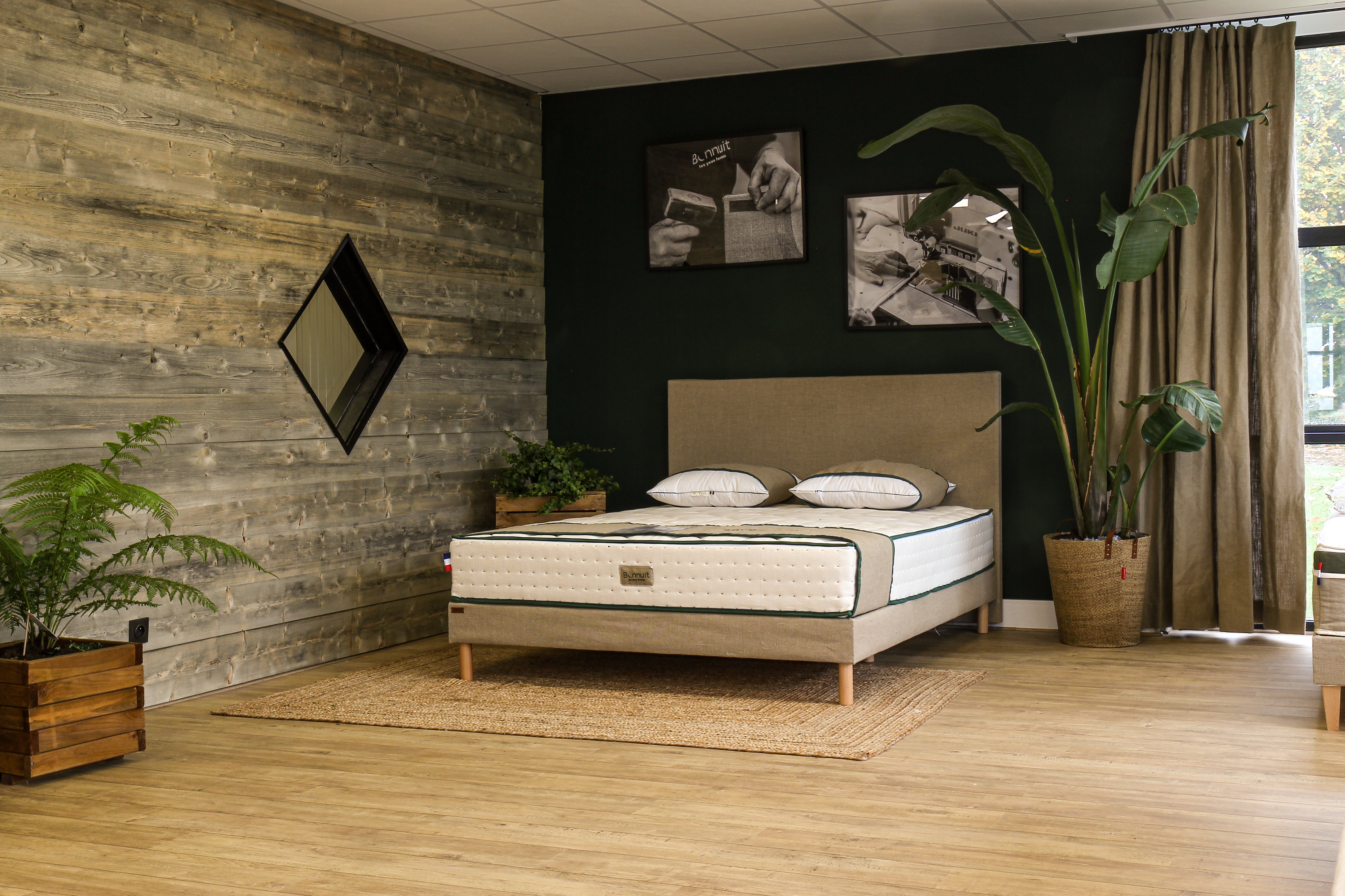 Literie complète exposée dans le showroom Bonnuit à Bondues avec décoration végétale et éléments en bois naturel
