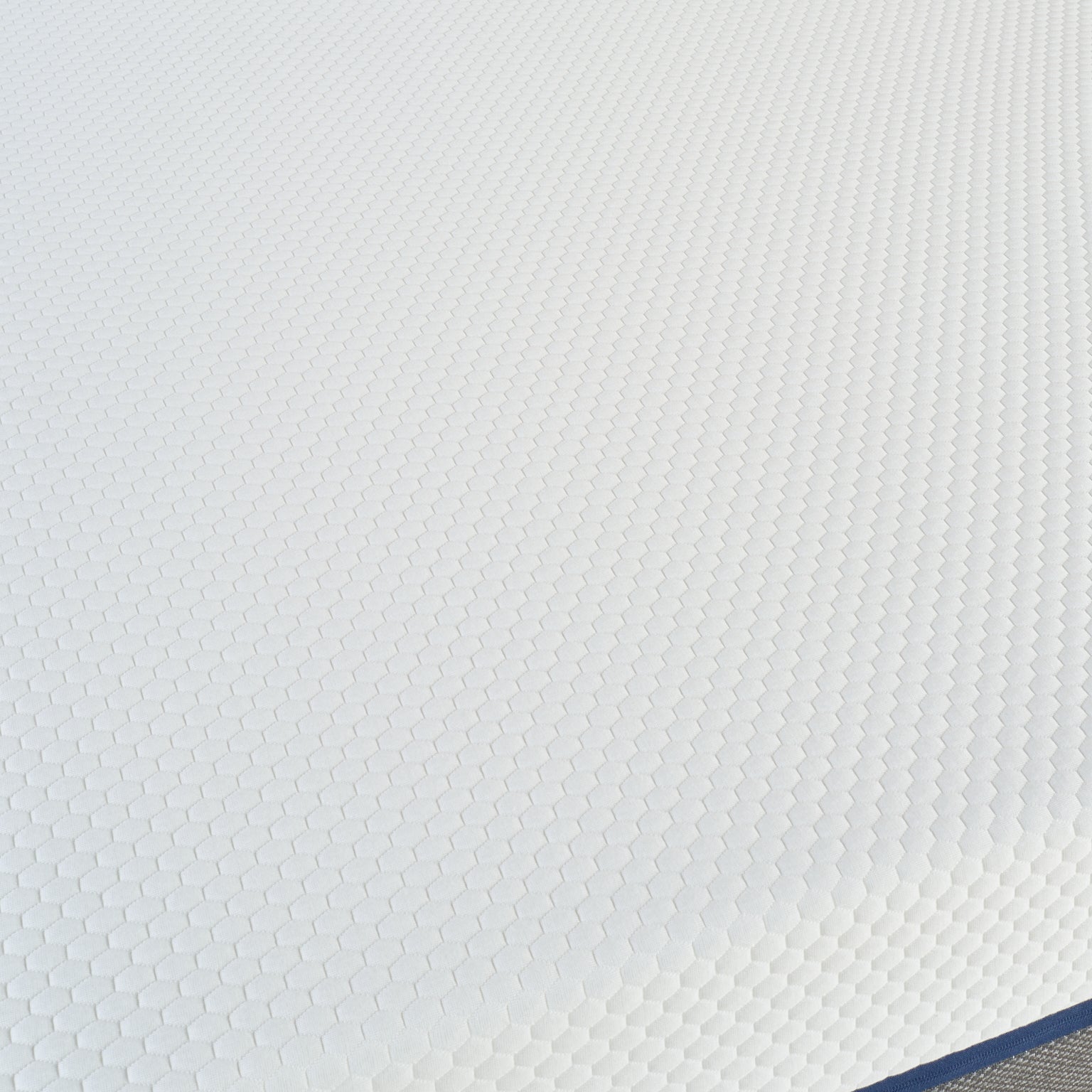 Vue de dessus du matelas L’Authentique Bonnuit avec zoom sur le tissu blanc de la housse et ses finitions
