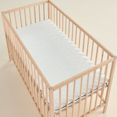 Matelas bébé Évolutif vu en angle, housse bicolore et liseré vert, format lit à barreaux