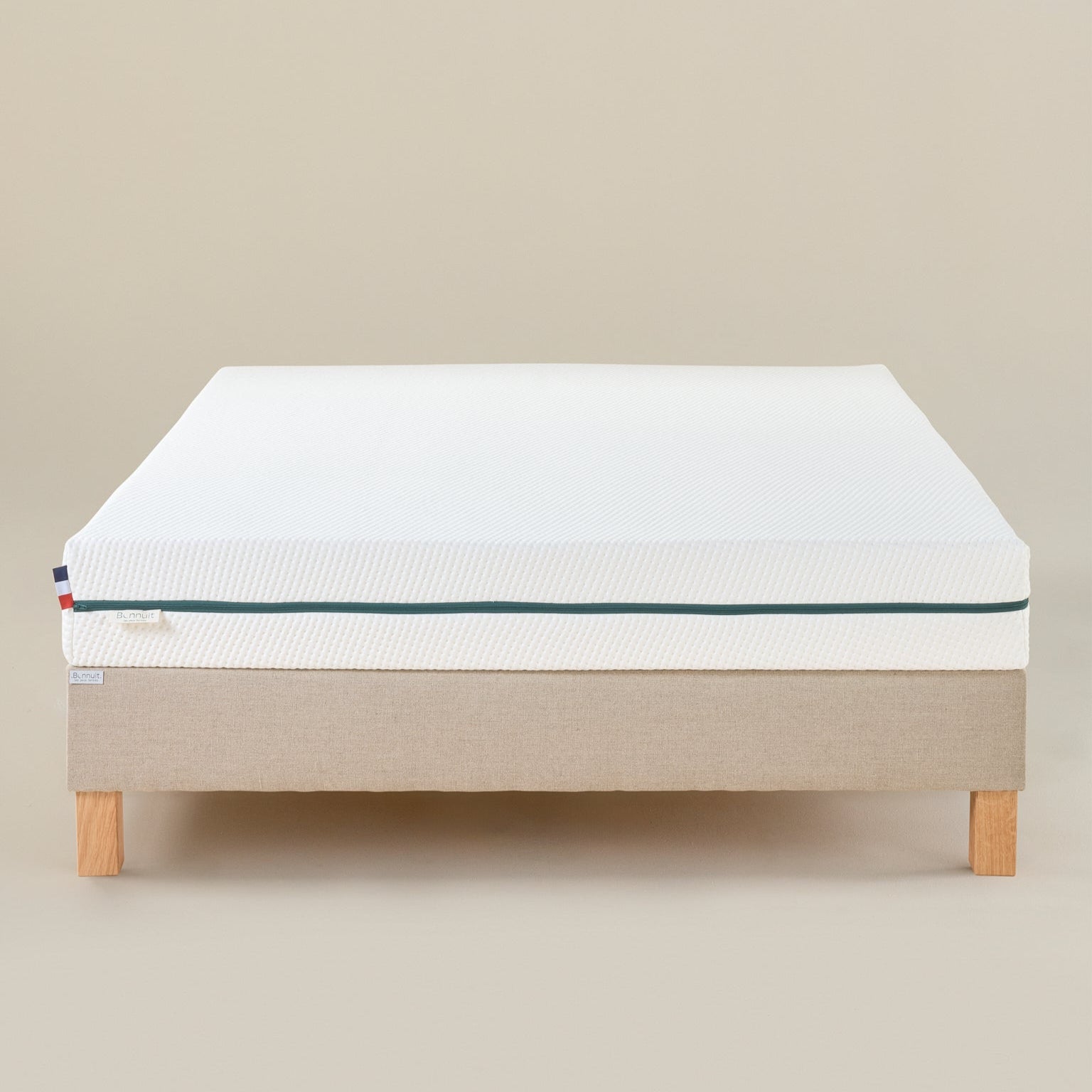 Matelas L’Essentiel Bonnuit en latex naturel et mousse, vue de face avec housse blanche, fermeture verte et drapeau français
