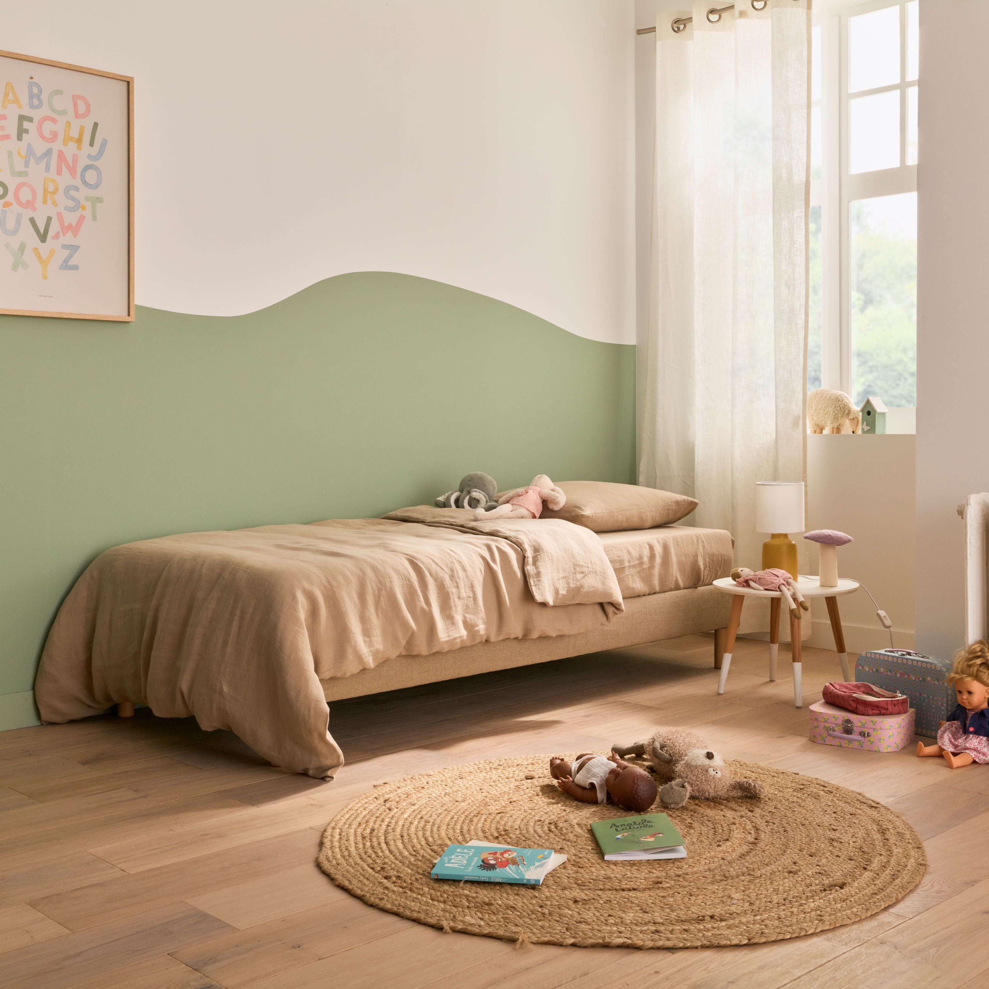 Chambre d’enfant avec le matelas L’Essentiel Bonnuit, jouets au sol et parure en lin lavé beige