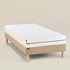 Matelas Le P’tit Mousse en mousse ferme vu en angle, housse bicolore et liseré bleu, format enfant