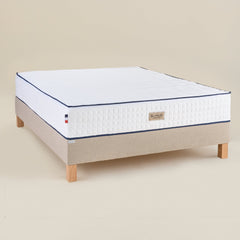 Matelas Le Majestueux Bonnuit en ressorts ensachés et mousse à mémoire de forme, vue 3/4 avec liseret bleu et logo brodé sur lin