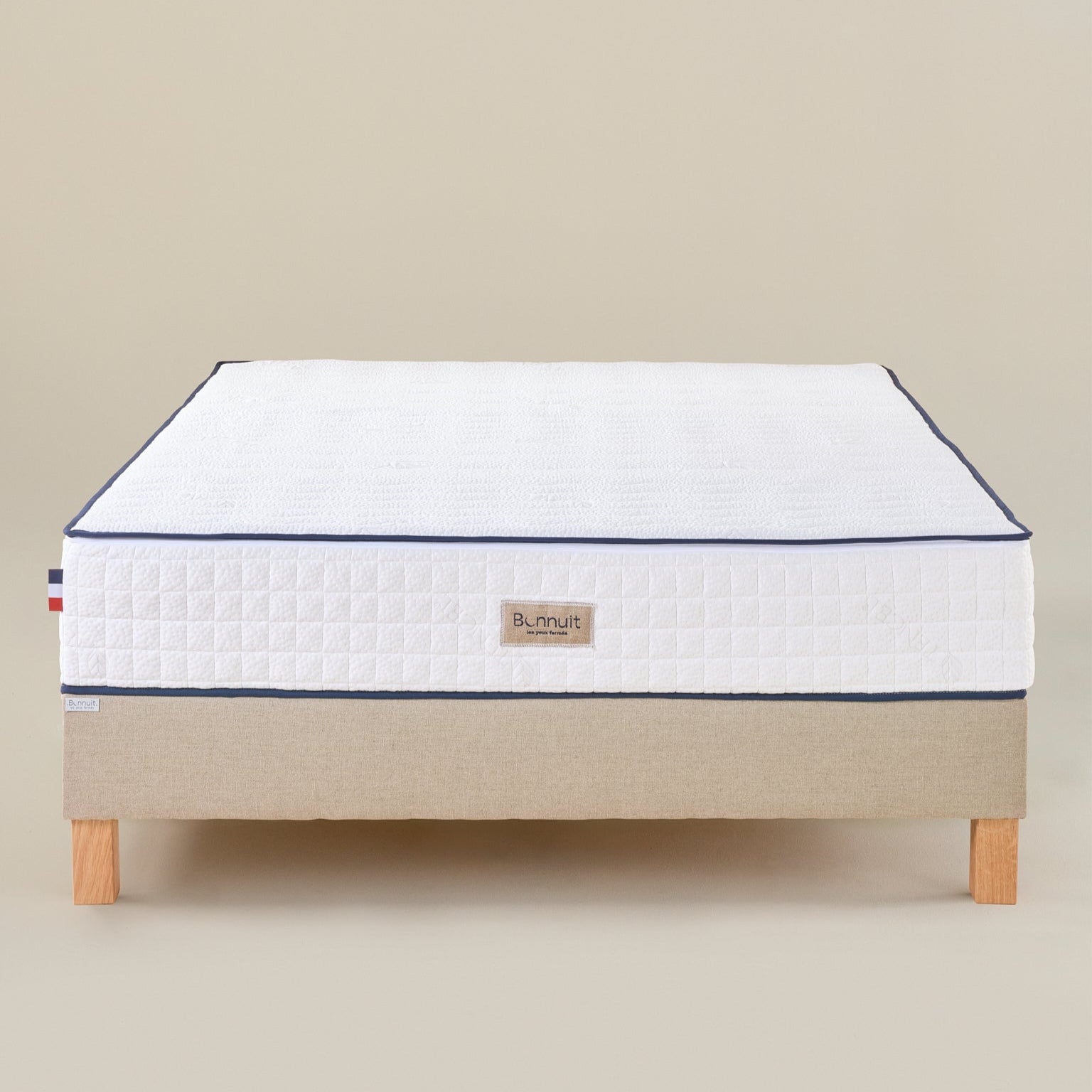 Matelas Le Majestueux Bonnuit en ressorts ensachés et mousse à mémoire de forme, vue de face avec liseret bleu et logo brodé