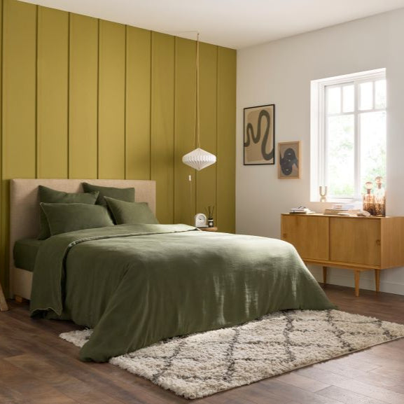 Matelas Le Merveilleux Bonnuit habillé d’une parure en lin lavé kaki, dans une chambre à la déco naturelle et apaisante
