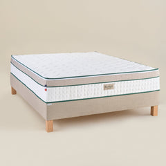 Matelas Le Merveilleux Bonnuit en ressorts ensachés et latex naturel, vue 3/4 avec bande en lin lavé, liseret vert, logo brodé et drapeau français
