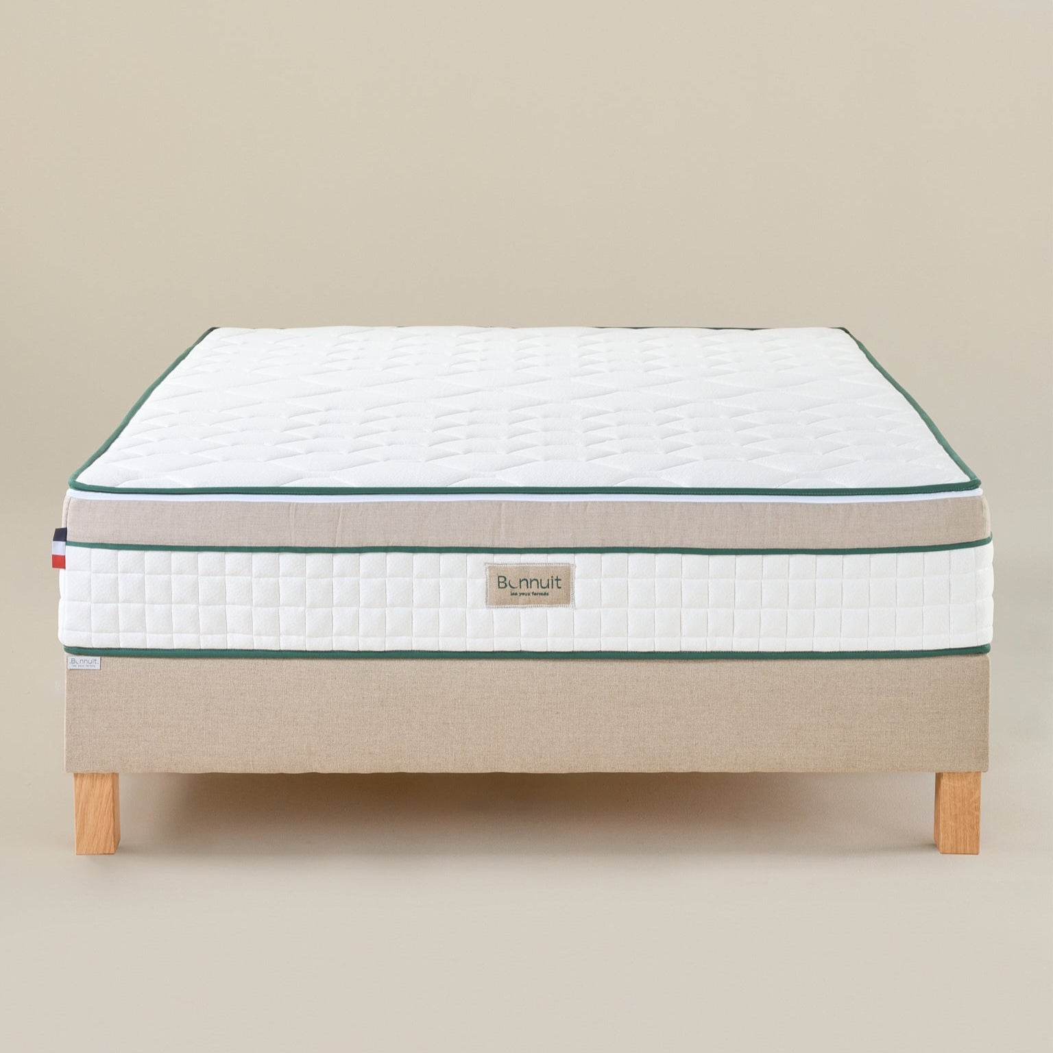 Matelas Le Merveilleux Bonnuit en ressorts ensachés et latex naturel, vue de face avec bande en lin lavé, liseret vert, logo brodé et drapeau français