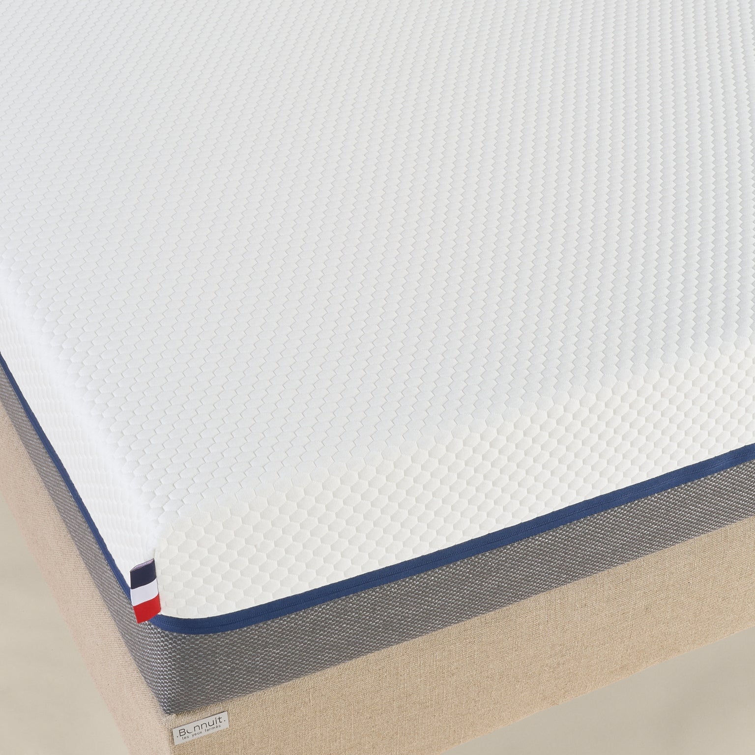 Vue de dessus du matelas Le Nuage Bonnuit avec zoom sur la housse bicolore et son tissu doux