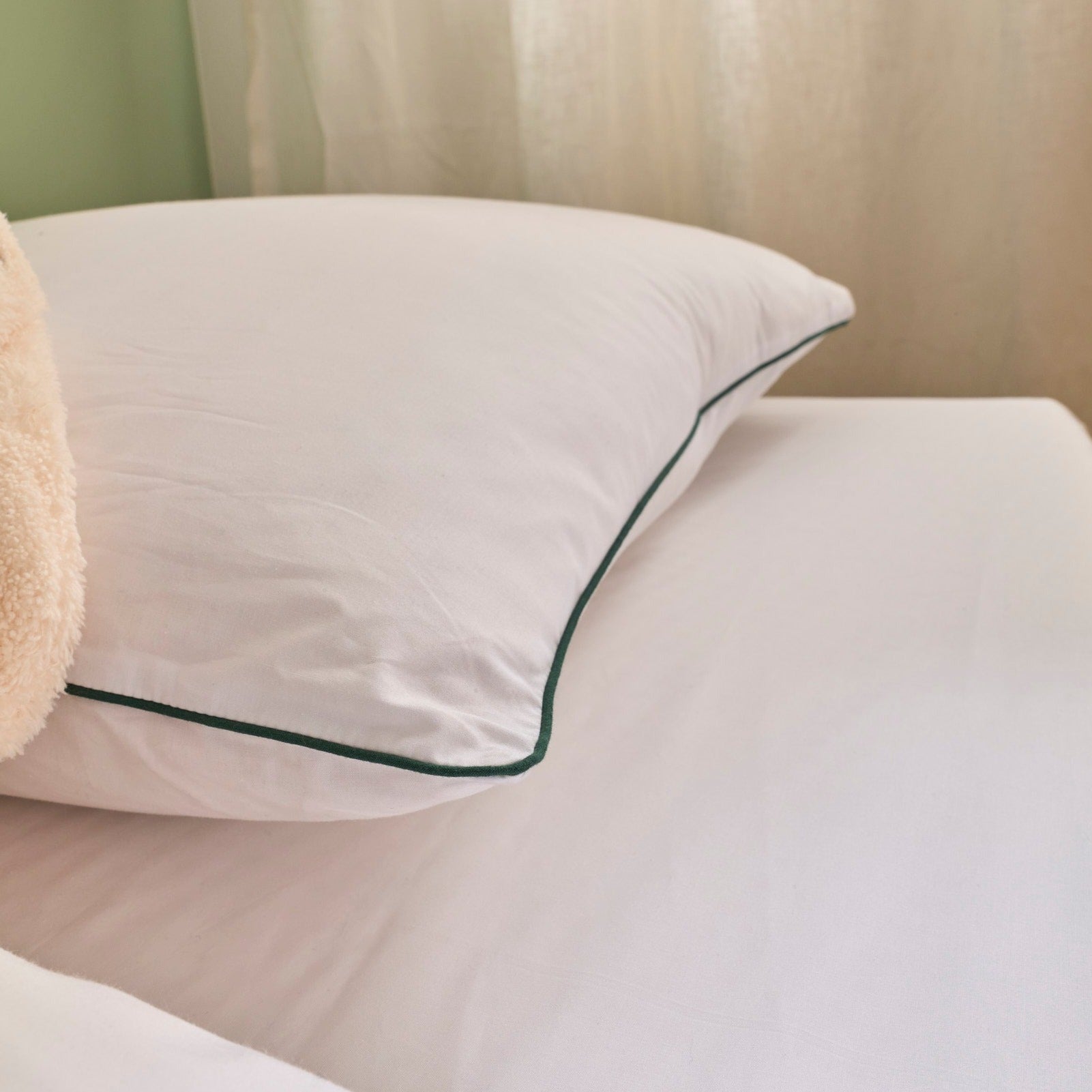 Zoom sur la housse de l’oreiller Incontournable avec liseré vert, tissu en percale de coton doux