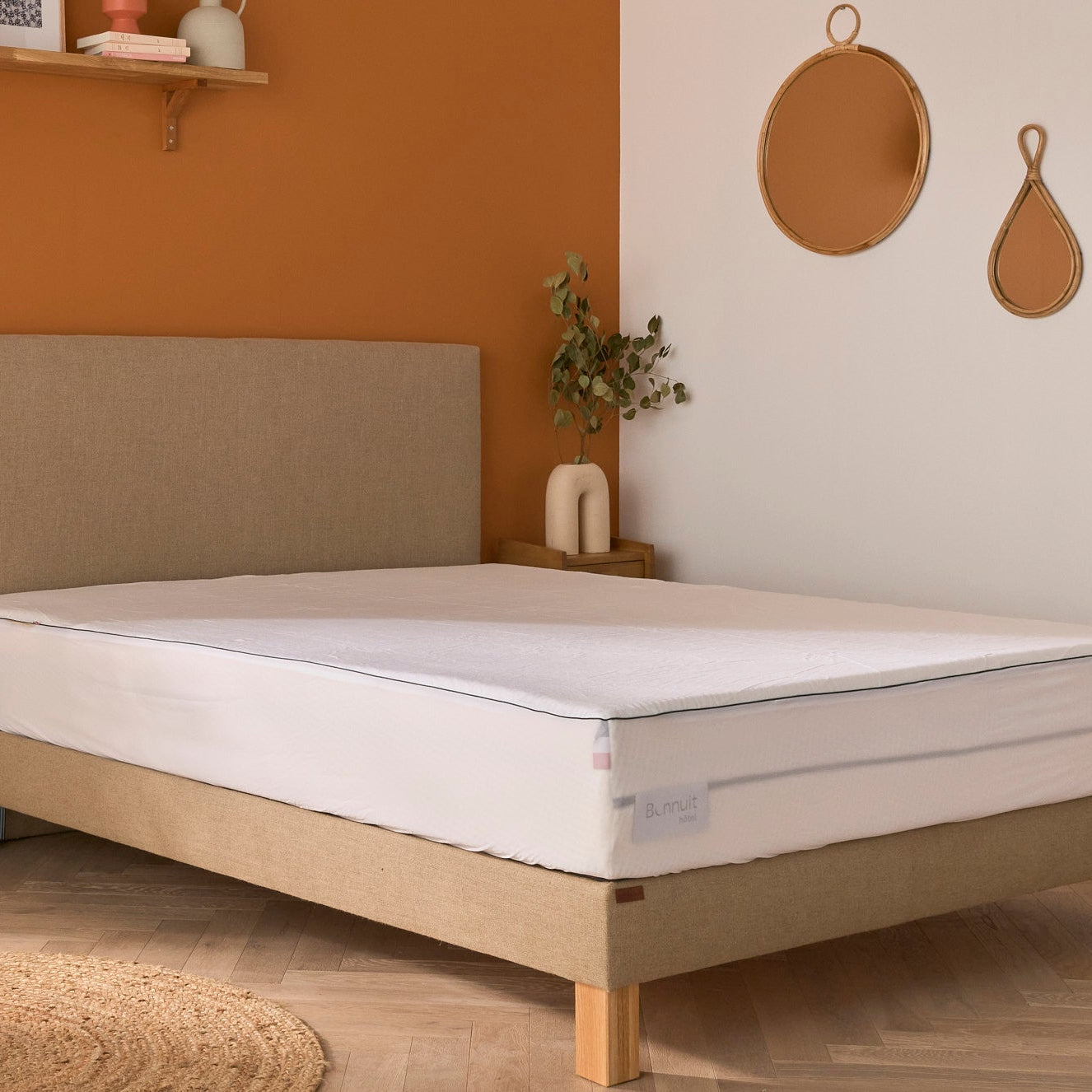 Protège-matelas Bonnuit installé sur le matelas dans une chambre décorée, literie complète et ambiance soignée