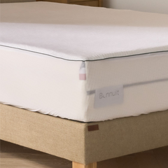 Zoom sur le côté du matelas avec protège-matelas Bonnuit, étiquette visible, drapeau BBR et liseré vert, côtés transparents