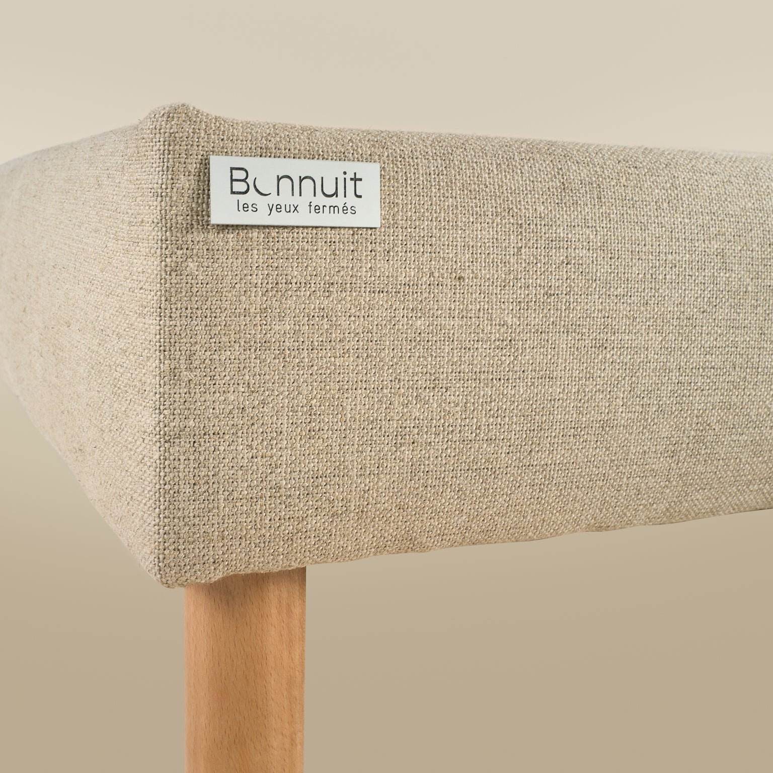 Zoom sur la plaque Bonnuit en métal fixée sur le côté du sommier L’Indispensable en lin naturel