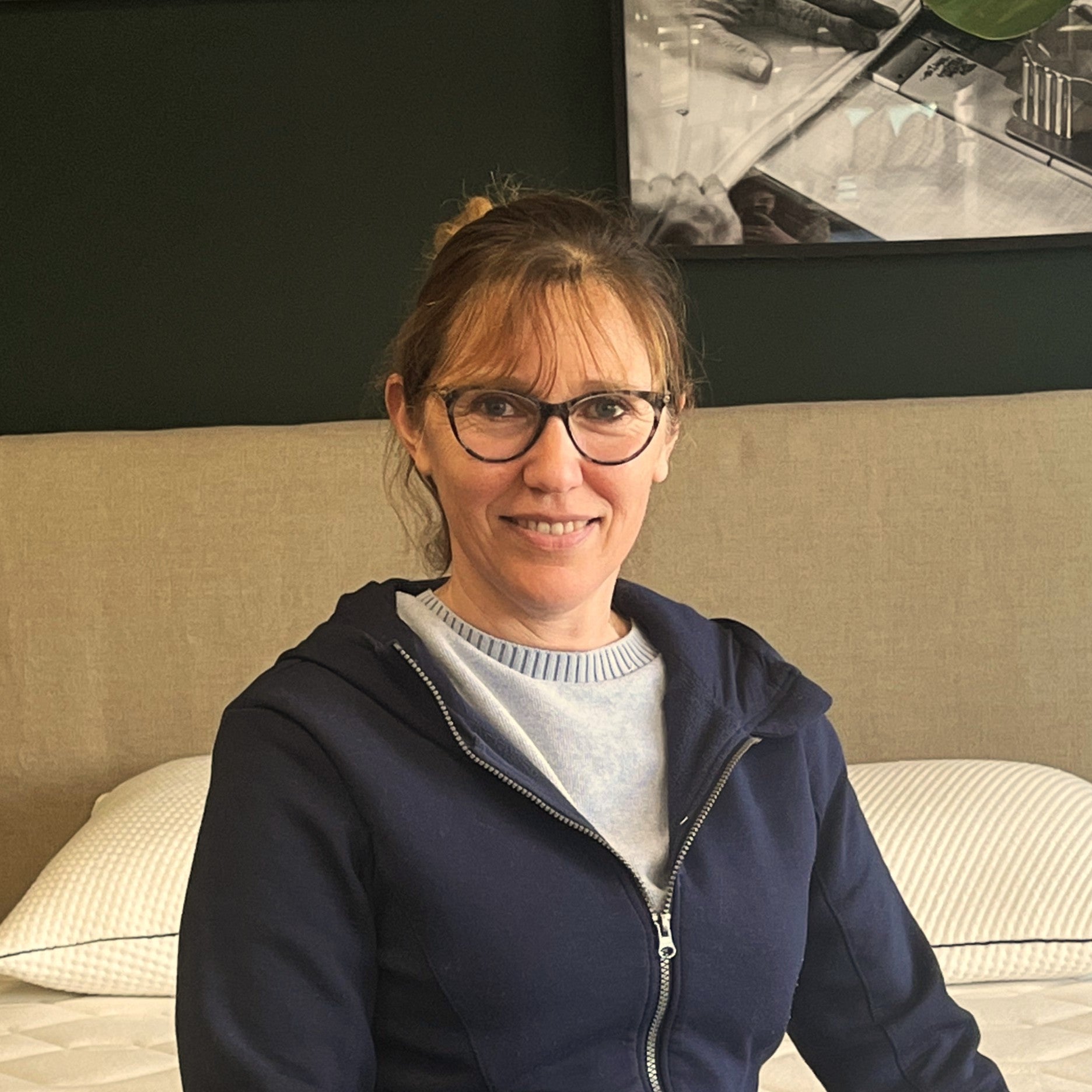 Stéphanie, couturière Bonnuit, assise sur un lit, regard doux et posture détendue