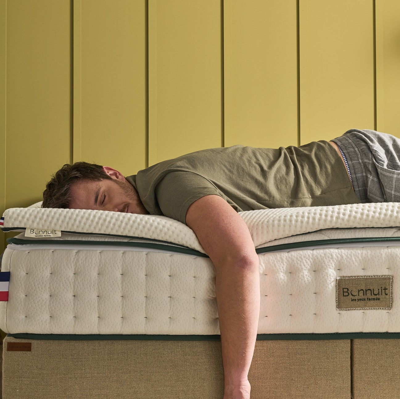 Homme allongé sur le lit avec le surmatelas Aérien Bonnuit, sensation de confort et détente