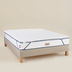 Surmatelas Enveloppant Bonnuit vu en 3/4 sur un matelas, mousse à mémoire de forme, finition douce