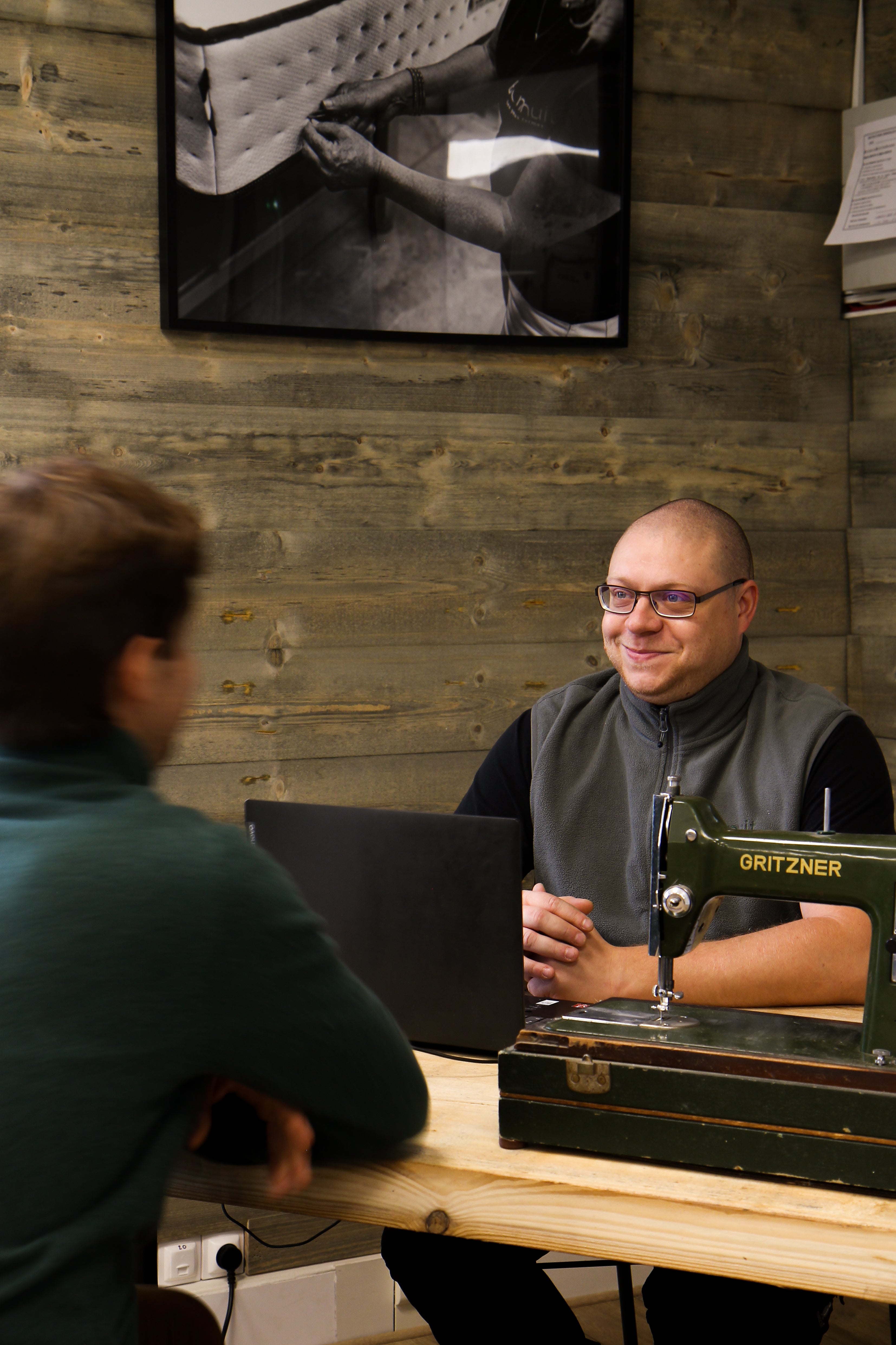 Vendeur Bonnuit en échange avec un client dans le magasin de Bondues, avec une machine à coudre visible au premier plan