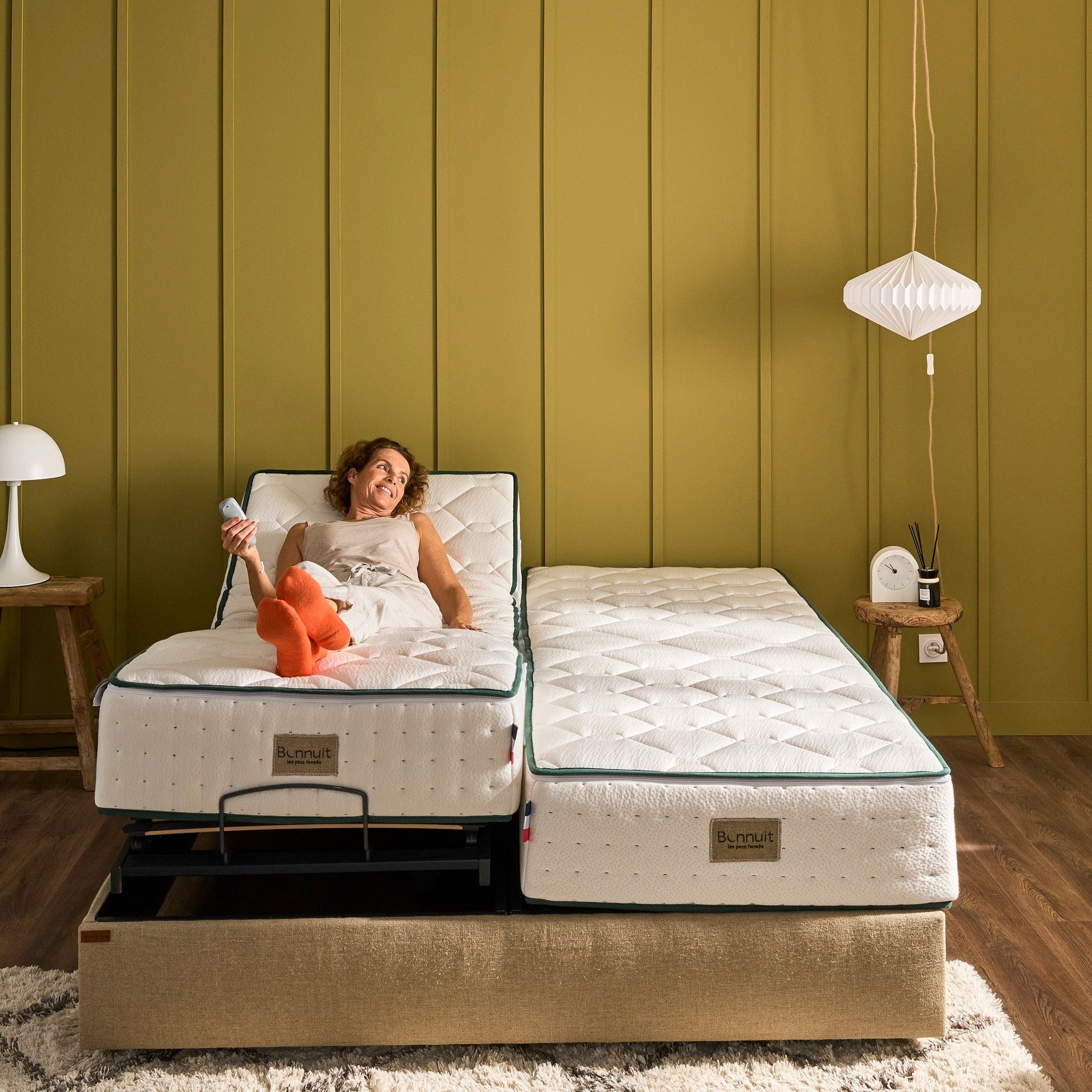 Femme souriante sur un des deux matelas du sommier électrique Divin, couchage double indépendant