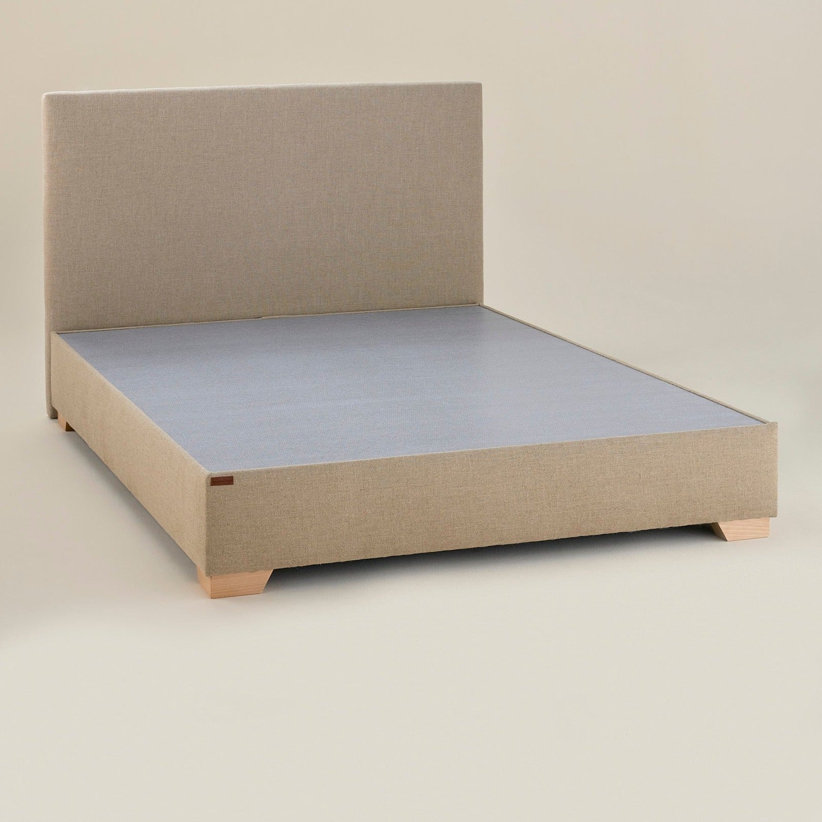 Sommier Royal vu en 3/4 avec tête de lit assortie en lin naturel, ensemble harmonieux et finition soignée